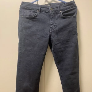 Mörkblå jeans från J.Lindeberg - Snygga mörkblå jeans från J.Lindeberg med klassisk femficksdesign och knappgylf. Passar för alla dagar 