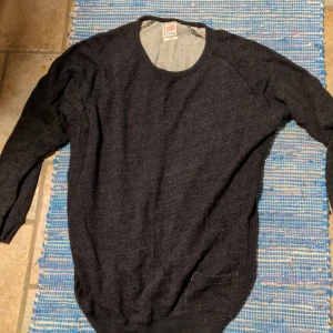 Mörkgrå tröja från Vaillent Clothing - Säljer en stilren mörkgrå tröja från Vaillent Clothing. Tröjan har en klassisk design med rund hals och långa ärmar, perfekt för kyligare dagar. Passar bra till både jeans och chinos.