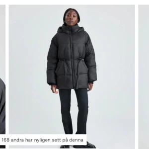 Svart pufferjacka med huva - Snygg och varm svart pufferjacka med huva och dragsko i midjan. Perfekt för kyliga dagar. Jackan har långa ärmar och en stilren design. Köptes förra året men använd max två gånger så den är precis som ny, utan prislapp bara. Köptes för 999kr.