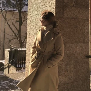 Beige kappa från H&M - Snygg beige kappa från H&M med knytskärp i midjan. Perfekt för höst och vår, med långa ärmar och klassisk design. Ett stilrent val för kyligare dagar.