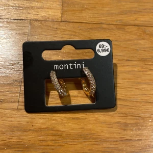 Guldörhängen från Montini - Snygga guldörhängen från Montini med glittriga detaljer. Perfekta för att ge en touch av glamour till din outfit. Kommer i originalförpackning från Ur & Penn. Ingen har använt dom.