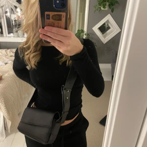 Svart axelväska i skinn - Snygg svart axelväska i skinn med justerbar axelrem. 