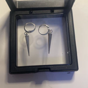 Silvriga örhängen med konformade hängen - Snygga silvriga örhängen med konformade hängen. Perfekta för att ge en edgy touch till din stil. De är lätta och bekväma att bära hela dagen.