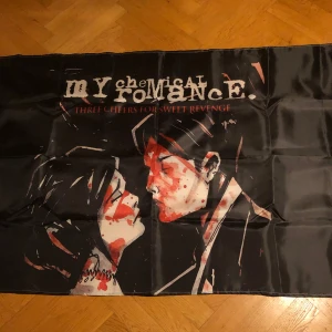 My chemical romance flagga - Flagga med My Chemical Romance album Three cheers for sweet revenge. Ca 130x90 cm. Perfekt att ha på väggen eller i taket. Om nån vill ha fler bilder skriv bara så fixar jag det