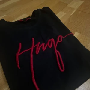 Svart/Röd Hugo Boss T-Shirt - Säljer Svart/Röd Hugo Boss T-Shirt, pga att den inte passar mig längre. Jätte bra skick, knappt använd.