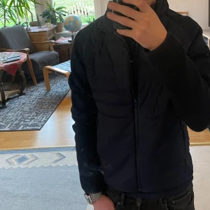 Mörkblå cardigan från Dressman - Säljer en stilren blå cardigan med dragkedja. Jackan har långa ärmar och en modern passform, perfekt för kyligare dagar. Den är både praktisk och snygg.  Mycket fin cardigan från dressman säljer den då jag växt ur den. Inga skador och nytt skick. Använt ett fåtal gånger och ny pris ligger på 1200 kr.