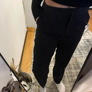 Svarta kostymbyxor - Snygga svarta kosymbyxor med hög midja och en stilren design. Använt ba några gånger.