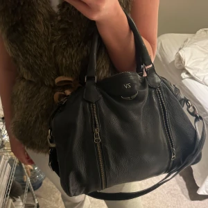 Zadig & Voltaire  - Snygg svart skinnväska med dubbla handtag och justerbar axelrem. Väskan har två framträdande dragkedjor på framsidan och en diskret logotyp. Inga defekter som ny 