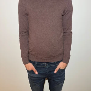 Brun tröja från Dressmann - Säljer en stilren brun tröja från Dressmann i Supima bomull. Tröjan har en klassisk design med långa ärmar och ribbade muddar. Perfekt för en avslappnad men ändå välklädd look.