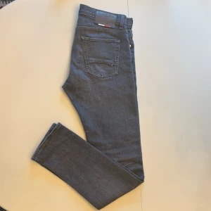 Grå jeans från Tommy Hilfiger - Snygga gråa jeans från Tommy Hilfiger. Modellen är Blecker i storlek L34 W32