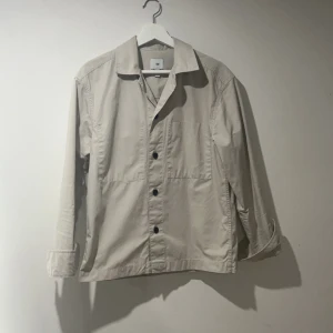 Beige overshirt - Säljer en stilren beige overshirt från hm, helt slutsåld. Nypris 399kr. Storlek xs. Men sitter som S