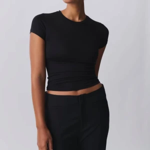 Svart  t-shirt - Säljer en svart soft touch top från Gina tricot i storlek S💕 tröjan sitter tajt och skapar en fin passform💕 använd ett fåtal gånger