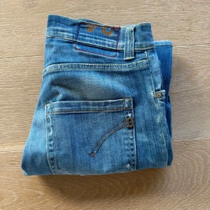 Blå jeans från Bonobo - Säljer ett par snygga blå jeans från Dondup i bra skick. De har en klassisk femficksdesign med en cool slitning på ena benet. Perfekta för en avslappnad stil och passar till det mesta. . Perfekta för både vardag och fest! Hör av er vid minsta fundering.
