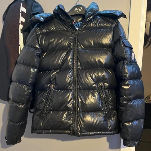 Svart dunjacka från Moncler - Snygg svart pufferjacka från Moncler Maya med glansig finish. jackan passar dig mellan 165-175. jackan är självklart äkta kolla bilderna 4/5. hör av er vid funderingar, mer bilder osv. Priset är ej hugget i sten och byten kan även vara intressant👍