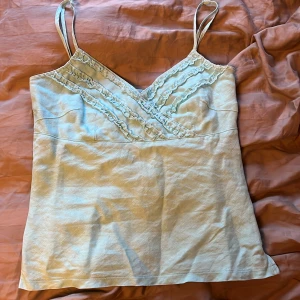 Söt vintage top - Ljusblå linnetopp från Sisters. Toppen har fina detaljer framtill och så snygg när man är brun 😍😍Är vintage så är svårt att få tag i, pris kan diskuteras! Passa på när det är fri frakt i endast någon dag till❤️