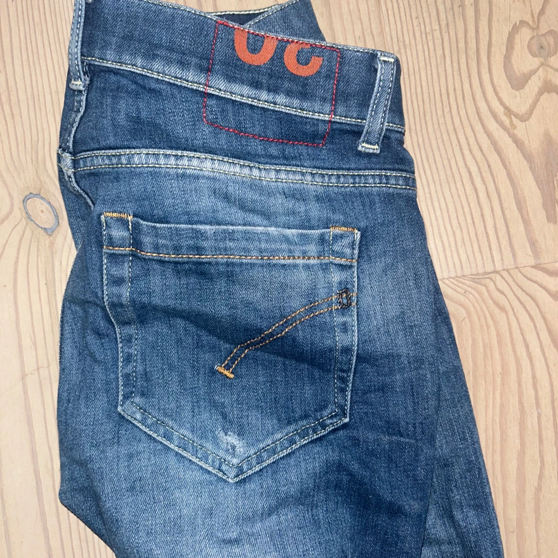 Blå jeansbyxor med orange detalj