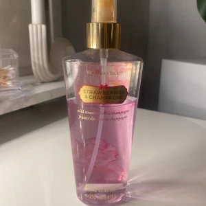 Victoria's Secret body mist  - Fräsch och fruktig body mist med doft av jordgubbar och champagne. Flaskan är genomskinlig med rosa vätska och har en gyllene spraypump. Perfekt för en uppfriskande känsla. Använd men för länge sedan, trött på doften nu för tiden.