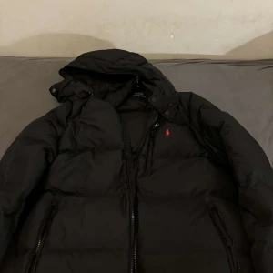 Svart dunjacka från Ralph Lauren - Snygg svart dunjacka från Ralph Lauren i storlek medium. väldigt varm jacka som är perfekt inför kalla dagar. Jackan är köpt här på plick men säljer för att den är för stor för mig. Är inte helt säker på äkthet😁