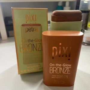 Pixi On-the-Glow Bronze richglow - Pixi On-the-Glow Bronze är en fuktgivande bronzer i stickformat. Perfekt för att ge ansiktet en solkysst look med en naturlig glöd. Enkel att applicera och smidig att ta med sig. Shade: richglow. Använts 1-2ggr. Nypris: 230kr