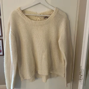 Stickad tröja med fläta i ryggen - Stickad tröja med fläta i ryggen. Köpt second hand men fint skick😋 Beige/krämvit/vit