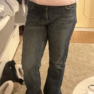 Blå jeans från Jenny - Säljer ett par klassiska blå vintage jeans från Jenny. De har en bekväm passform med en bootcut stil och är perfekta för vardagsbruk. 