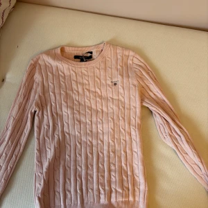 Rosa kabelstickad tröja från GANT - Säljer en stilren rosa kabelstickad tröja från GANT. Använd ca 10 ggr. Pris kan diskuteras 