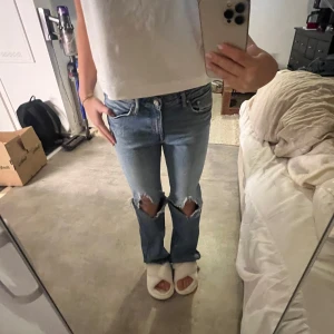 Blå jeans med slitningar - .Så snygga lågmidjade jeans med slitningar!! Jeansen har inget märke vad jag kan se men skulle säga att storleken är 36 eller 38 Midja : 39cm Innerbenslängd: 76