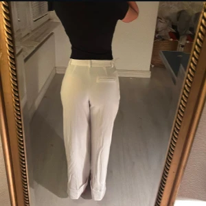 Vita kostymbyxor  - Snygga vita kostymbyxor med hög midja och rak passform. Perfekta för en stilren look. Byxorna har fickor och är vikta nertill. Jag är 1.70 lång, aldrig använt byxorna.