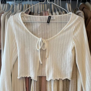 Söt cardigan - Säljer en söt vit bolerotopp i stl xxs. 🌸💓 har liten dragning vid armslutet. Öppen för prisförslag!