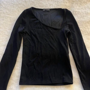 Svart långärmad topp från Zara - Snygg svart långärmad topp från Zara med en unik asymmetrisk halsringning. 🥰