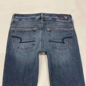 Lågmidjade/mid waist bootcut jeans från American Eagle🤩 - Midja 37 cm plus stretch rakt över, gren 21 cm o innerben 82 cm💕jae 169 o xs-s för referens. Märkta storlek 4 vilket jag uppskattar till xs-s. Obs jag har sprättat upp dem efter förra säljaren som sytt upp dem (bild 2 visar bäst)