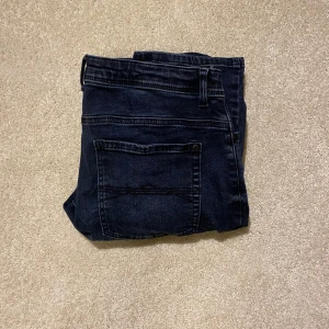 Mörkblå jeans från Next - Snygga mörkblå jeans från Next i regular fit. Klassisk design med fem fickor och knappgylf. Perfekta för en avslappnad stil. Priset kan diskuteras
