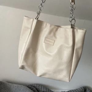 Beige axelväska - Jag säljer en beige/krämvit handväska från shein som jag använt ganska mycket då min ser att banden man håller i är lite slitna och lite mer(kan skicka mer bilder privat) riktigt bra material för att vara shein för jag har använt den i flera år💗