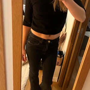 Mörkblå stickad topp - Säljer en mörkblå stickad topp med trekvartsärm. Perfekt för en stilren look och passar bra till både jeans och kjol. Tröjan har en enkel design med rund hals och är bekväm att bära.