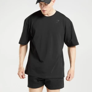 Svart oversized t-shirt från Gymshark - Urtvättad oversized svart t-shirt från Gymshark med logga på bröstet och stort tryck på ryggen🖤