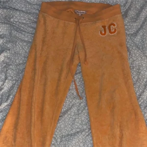 Orange mjukisbyxor från Juicy Couture - Snygga vintage byxor från Juicy Couture med broderad JC-logga på sidan. Byxorna har en bekväm resårmidja med snörning.  Älskar dom men tycker dom är lite för korta, använt en gång, men de är för korta för mig som är 169. LÄGG PRISFÖRSLAG!!kan sänka vid snabbaffär 