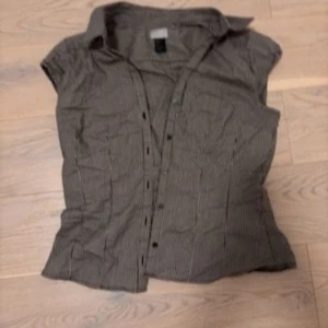 Svartvit randig blus - Snygg svartvit randig blus med korta ärmar och knappar framtill. Aldrig använt. Vintage