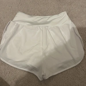 Vita träningsshorts - Snygga vita träningsshorts med elastisk midja och en bekväm passform. Perfekta för gymmet eller löprundan. De har två lager material så inget syns igenom  helt nya 