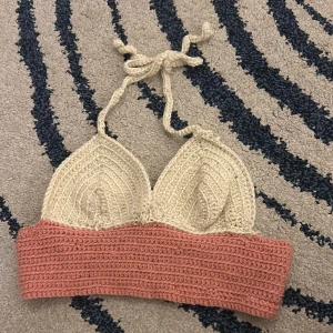 Stickad bikiniöverdel i beige och rosa - Stickad bikiniöverdel köpt i Grekland. Super skön och sitter jätte bra! Stickad med fina band som man knyter runt halsen storlek s-m❤️