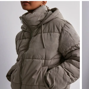 Jacka - Snygg beige puffig jacka från Nelly. Den är som ny och är inte använd så mycket.Snörerna i luvan saknas. Köparen står för frakt. 