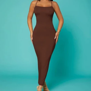 Brun långklänning - Elegant brun långklänning med smala axelband och öppen rygg. Perfekt för en stilren look. Endast använd en gång💗