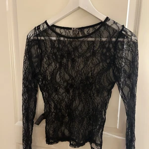 Svart spetsblus från Nelly - svart spetsblus från Nelly med långärmad design. 