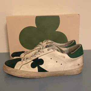 The Gallerist Skor - Snygga vita The Gallerist sneakers med gröna detaljer och en unik klöverdesign på sidan. Skorna är i fint använt skick dock är sulan lite sliten undertill därav relativt lågt pris🌟Nypris:2000 Box tillkommer✅