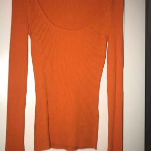Orange ribbad tröja från BikBok - Säljer en snygg orange ribbad tröja från BikBok. Tröjan har en rund halsringning och långa ärmar, perfekt för en färgglad look. Passar bra till både jeans och kjol. 🧡