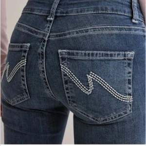 Blå bootcut jeans med broderade fickor - Snygga blå bootcut jeans med hög midja och coola broderade detaljer på bakfickorna. Perfekta för en avslappnad stil med en twist. Nästan aldrig använda 