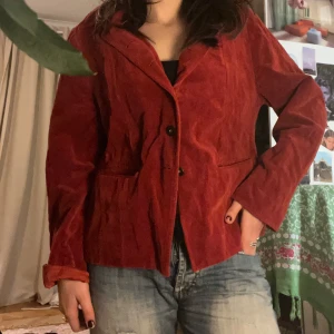 Röd manchesterkavaj - Snygg röd kavaj i manchester med knappar framtill. Perfekt för en stilren look, med långa ärmar och klassisk krage. Passar bra till både jeans och mer uppklädda outfits. Snygg oversized look.