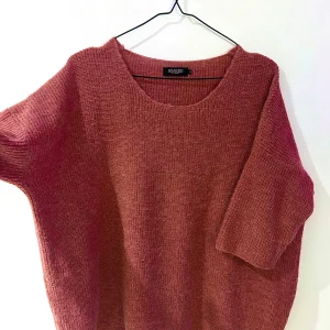 Rosa stickad tröja från Soaked in Luxury - Mysig rosa stickad tröja från Soaked in Luxury. Perfekt för kyliga dagar med sin bekväma passform och halvlånga ärm. Stickad i 30% alpacka, 25% ull, 25% polyamid, 20% akryl. Ett stilrent val för en avslappnad look.