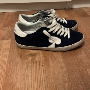 The gallerist skor  - Snygga sneakers i blått och vitt med snörning och en unik detalj på sidan. Perfekta för en avslappnad stil. Köpta i oktober och använda ett fåtal gånger. Skick: 8/10