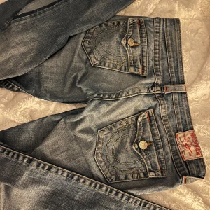 Blå jeans från True Religion - Jeans från true religion❣️De är g rise (väldigt lågmidjade) och är utsydda längst ner, De är strl 27 men lite stora i storleken💕skriv gärna innan köp!