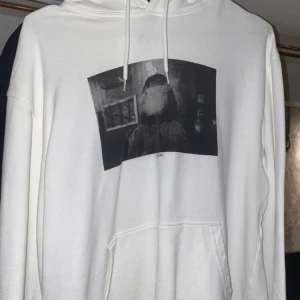 Vit hoodie med tryck - Säljer en vit hoodie med ett unikt tryck på framsidan. Hoodien har en klassisk design med känguruficka och justerbar dragsko i huvan. Perfekt för en avslappnad stil.